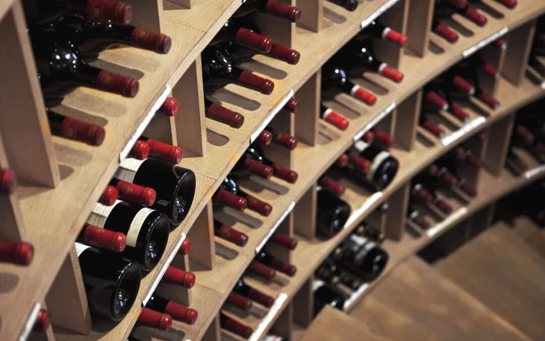 red wine lined on shelves in wine cellar